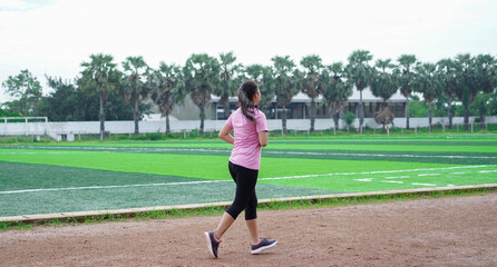 Fototapeta premium asian woman athlete running on track. back view