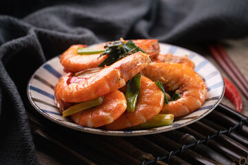 Delicious pan-fried shrimp on dark wooden table background.