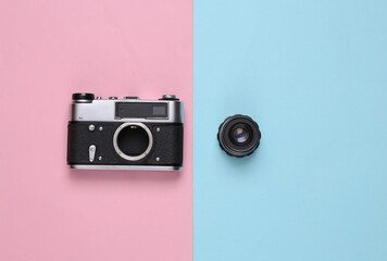 Vintage camera with lens on blue-pink pastel background. Top view