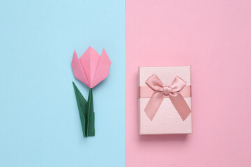 Handmade origami tulip and gift boxes on pink blue background. 8 March, women's day or birthday...
