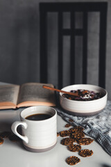 cup of latte or cappuccino coffee with a book in coffee shop with vintage retro filter effect. Healthy breakfast, smoothies, nuts and granola