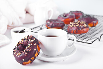 Doughnut glazed with chocolate cream or icing and cup of coffee. Breakfast concept.