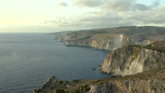 Flying over the huge Zakynthos coastal cliffs on the west side at sunset near Keri cliffs.