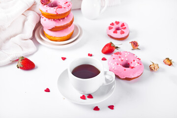 Cup of coffee and pink doughnuts on the white background. Valentine's Day concept.