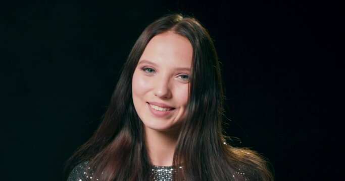 Head shot close up portrait of attractive smiling young brunete woman. Pleasant millennial girl looking at camera. She has a beautiful smile and a romantic look.