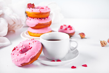 Cup of coffee and pink doughnuts on the white background. Valentine's Day concept.