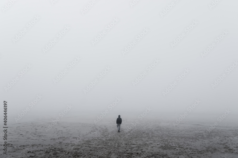 Wall mural unknown alone man in the fog, beach, baltic sea, slowinski national park, leba