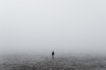 Fototapeta na wymiar Unknown alone man in the fog, Beach, Baltic Sea, Slowinski National Park, Leba