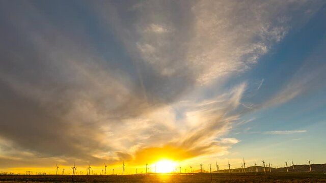 Wind turbines in the foreground, cloudscape overhead in this stunningly colorful sunset time lapse