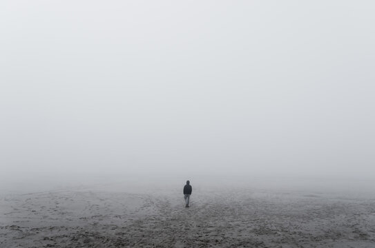 Unknown alone man in the fog, Beach, Baltic Sea, Slowinski National Park, Leba