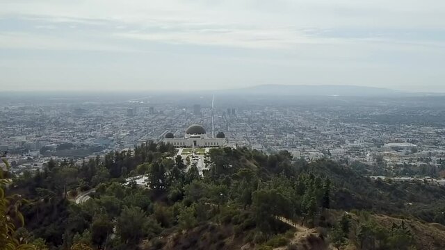 Skyline timelapse across Griffith observatory landmark downtown city Los Angeles pan right