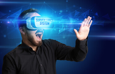 Businessman looking through Virtual Reality glasses with SURVEILLANCE SYSTEM inscription, cyber security concept