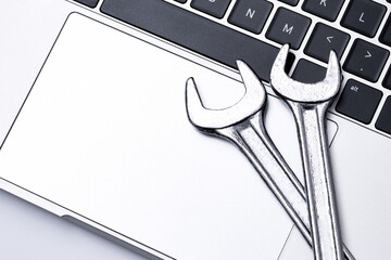 Computer repair service and IT industry support concept  - top view of steel metal wrenches on a laptop keyboard with copy space