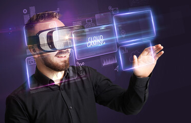 Businessman looking through Virtual Reality glasses with CLOUD GAMING inscription, new technology concept