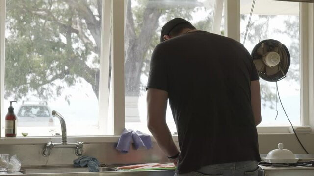 Mid shot of man in kitchen preparing salmon for curing.