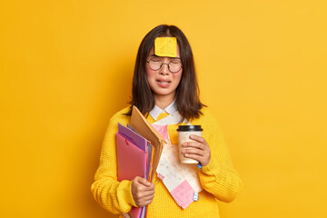 People and education concept. Upset Asian female student feels tired of exam preparation drinks...