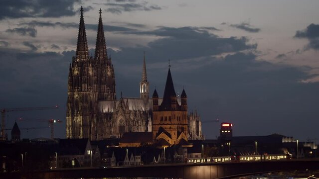 Cologne skyline with cologne cathedral and Gro&szlig; St. Martin. Zoo-Bridge in the foreground with two KVB trains driving on it.