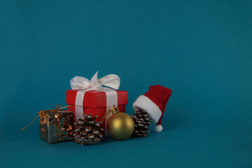 gift box, pine cones, christmas ball and Santa hat isolated on blue background. Christmas concept