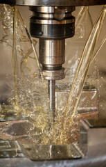 The vertical scene of CNC milling machine cutting the  mold parts with oil coolant method. The mold...