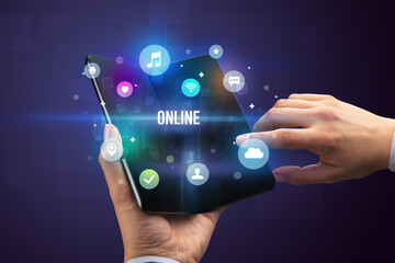 Businessman holding a foldable smartphone with ONLINE inscription, social media concept