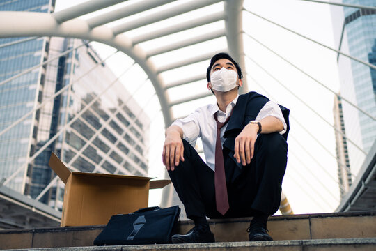 Asian Young Businessman Getting Laid Off, Sitting Outdoor In The City.