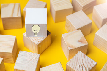 Creative idea, new idea, innovation and solution concept. wooden cubes with yellow light bulb symbol on the table, yellow, copy space
