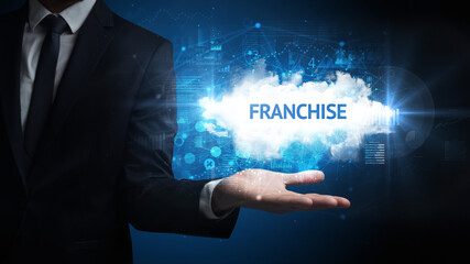 Hand of Businessman holding FRANCHISE inscription, successful business concept