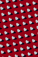 Pattern made from white wooden heart with strong shadow on red background, as symbol of love and passion, Happy Valentines Day Concept