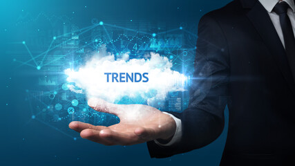 Hand of Businessman holding TRENDS inscription, successful business concept