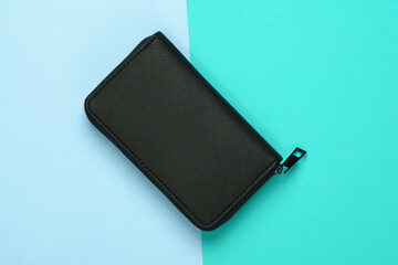 Black stylish wallet on blue pastel background. Top view