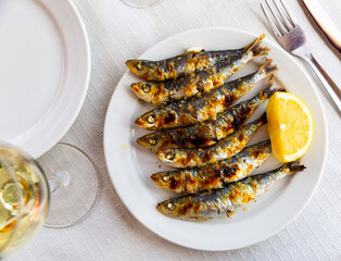 Grilled on fire sardines with lemon, popular andalusian dish