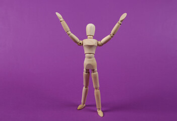 Happy wooden puppet mannequin on a purple background.