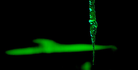 dynamic image showing an icicle with a green glow - obrazy, fototapety, plakaty