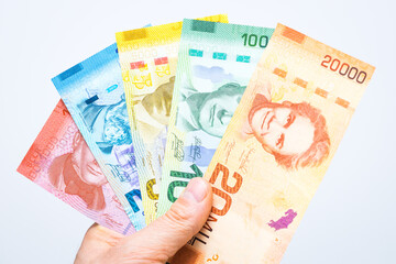 Costa Rican money, Colones, All banknotes fanned out and held in a male hand, White background