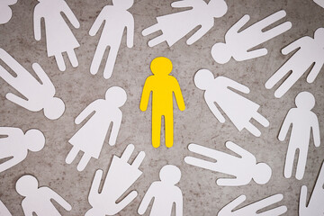 Yellow figure of a man against white silhouettes of women. Symbol of sexism.
