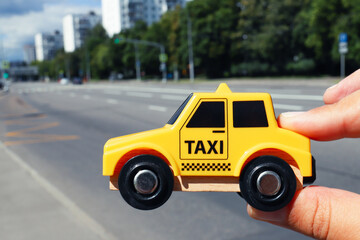 Yellow toy taxi car on street.