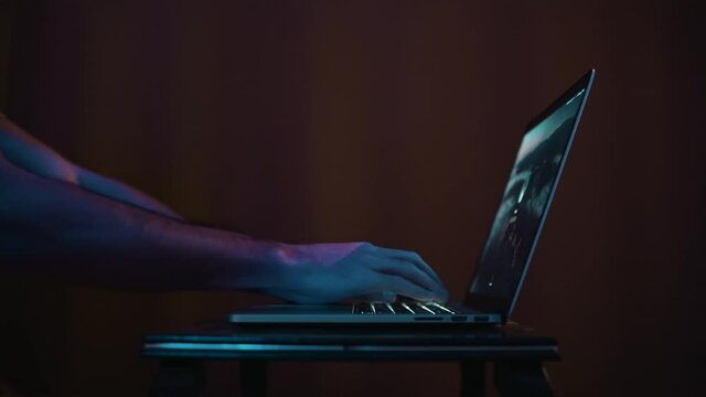 Opening and working on the laptop on the small table in dark room with blue light and closing laptop after working 2