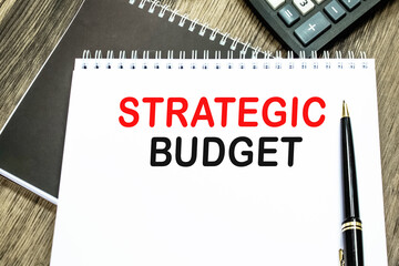 STRATEGIC BUDGET. Office workplace with supplies and reports . SELECTIVE FOCUS. You can use in business, marketing and other concepts. Messege of the day.