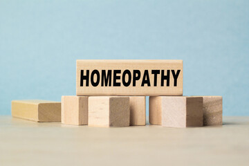 the word HOMEOPATHY is written on a wooden cubes structure . Cube on a bright background. Can be used for Medical concept. the medicine.