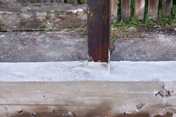 Building concrete foundation for new fence with steel poles. Foundation for future fence. 
