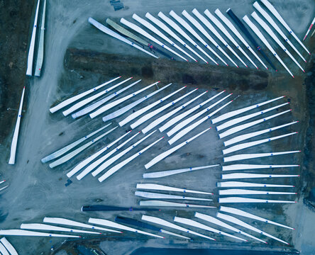 Blades for wind turbines stored outside of a factory waiting for shipping.