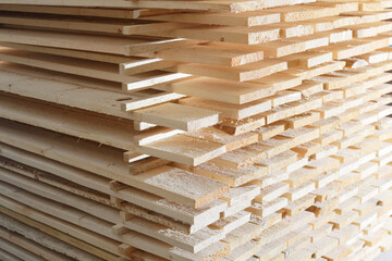Wooden boards are stacked in a sawmill or carpentry shop. Sawing drying and marketing of wood. Industrial background
