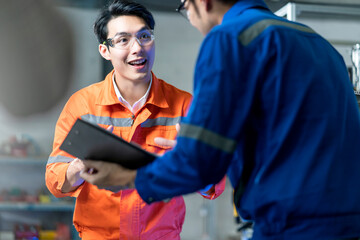 Male Asian engineer professional  having a discussion standing by the machine in the factory ,two asian coworker brainstorm explaining and solves the process curcuit mother board of the machine