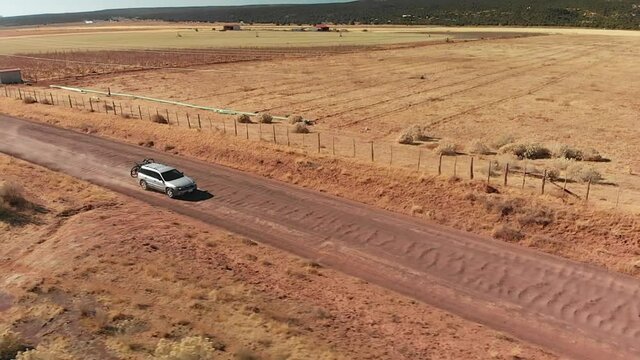 Silver Station Wagon with Bike Rack on Red Desert Road, Aerial