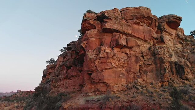 Reveal of Moon and Open Desert Mesa Over Red Rock Lip at Dusk, Aerial