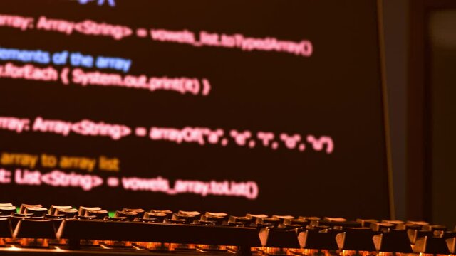 Hacker's keyboard is in the foreground with code scrolling across the screens in the background