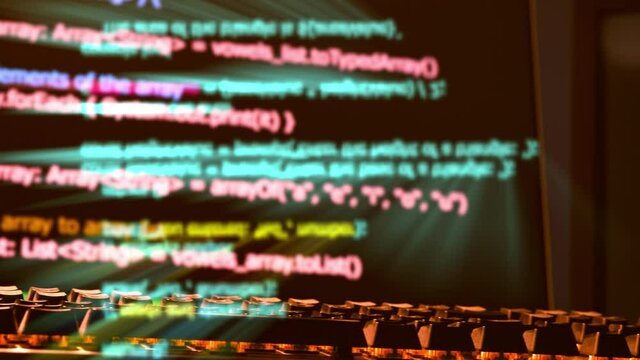 Computer screen and keyboard displaying programing code from a virus or hacker