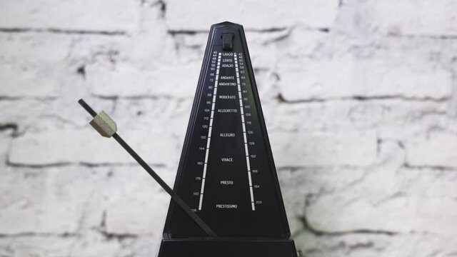 Antique metronome with pendulum in slow motion. Vintage wooden classic style. Equipment of music, beat, rhythm mechanism. 4K 25fps Video Footage.
