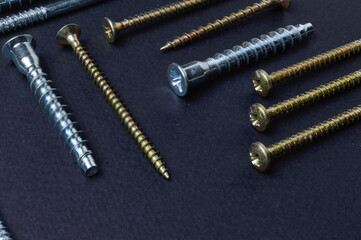 self-tapping screws and various fittings are laid out on a dark background. close-up.