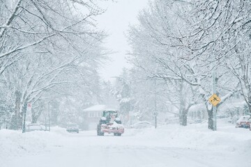 Montreal, Canada - Jan 16, 2021: Plows clear snow from a street during a snowstorm in Montreal